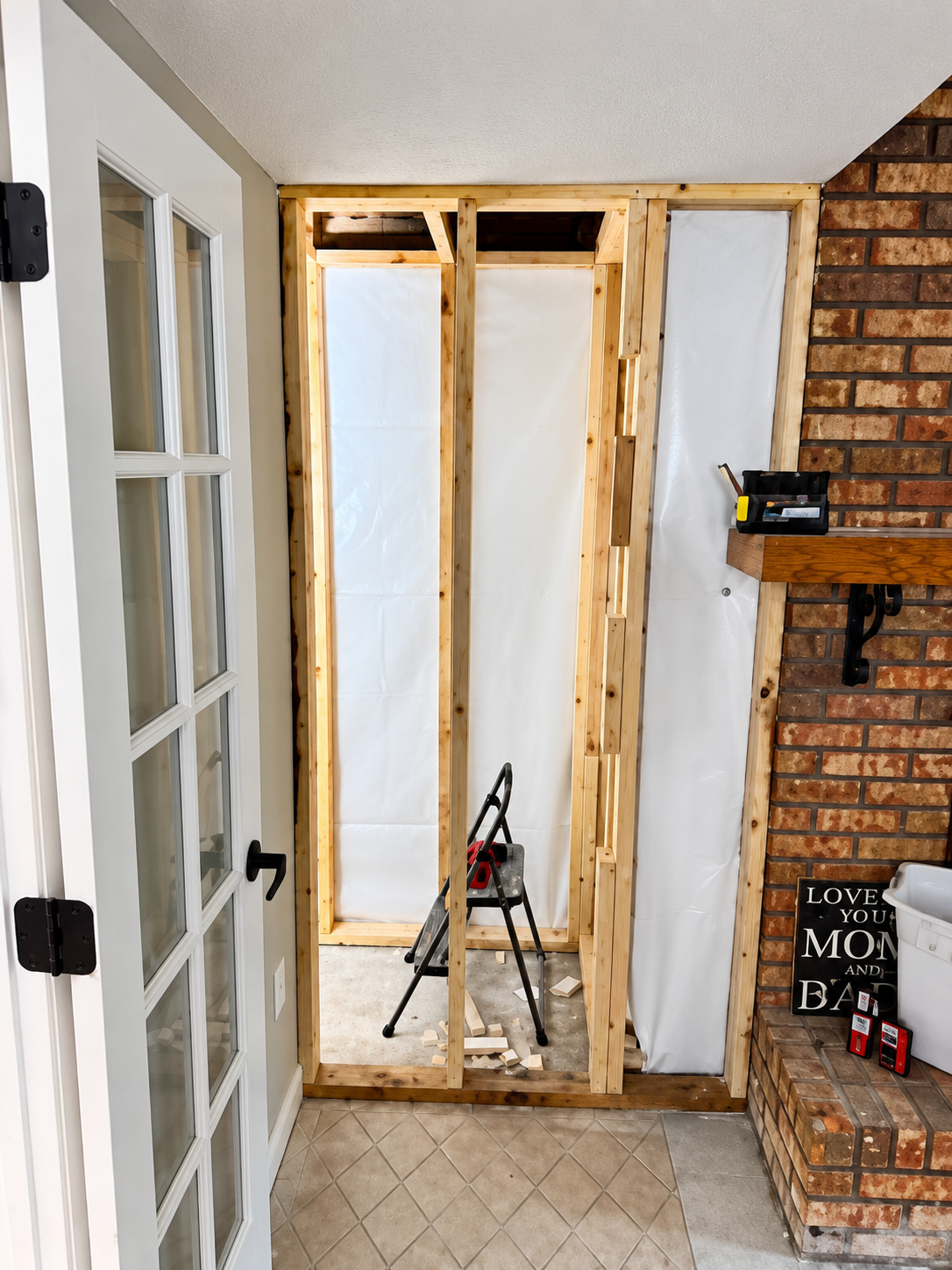 Bathroom Remodeling Project with Wooden Framing Next to Brick Wall