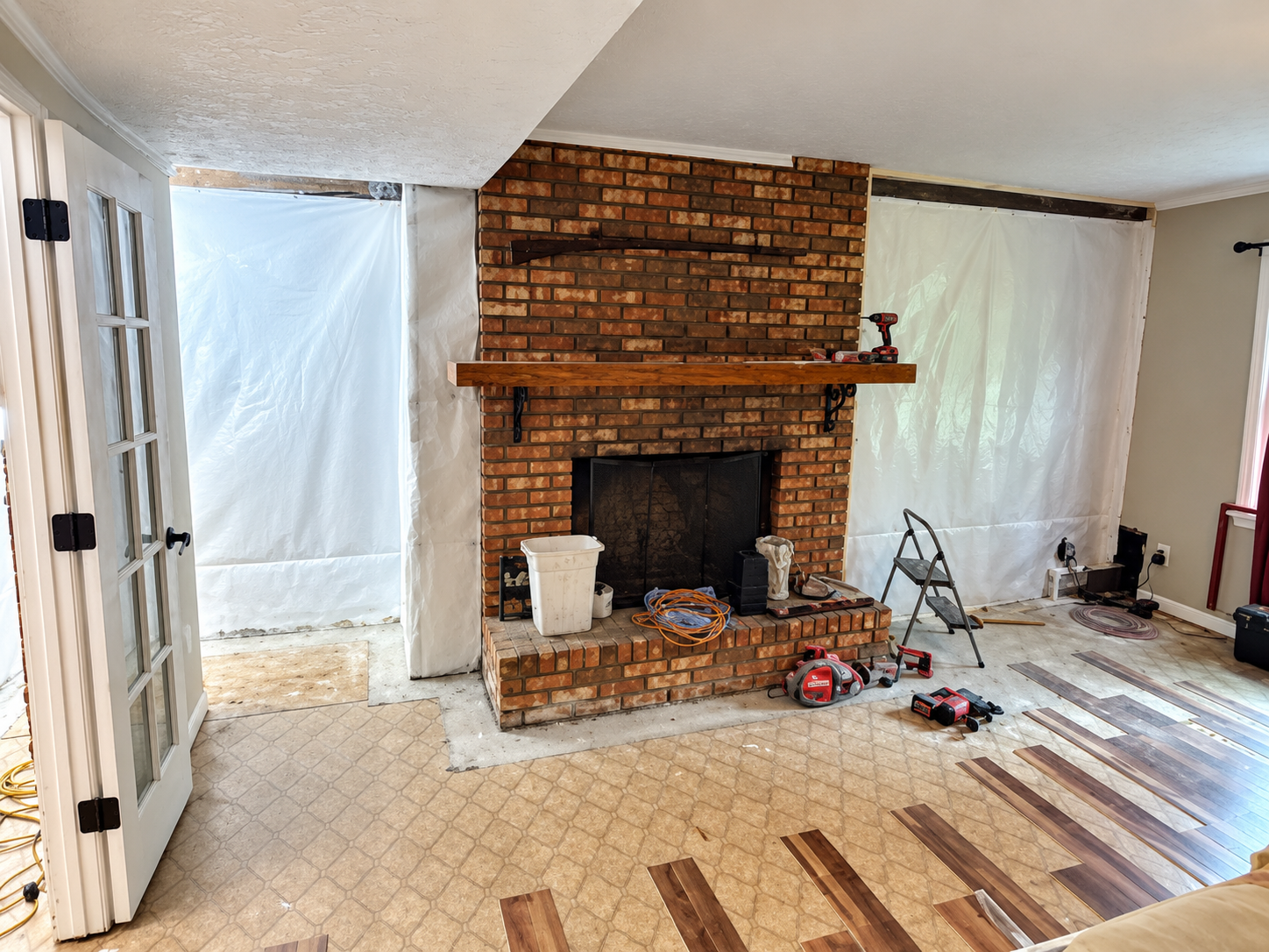 Living Room with Brick Fireplace Undergoing Home Remodeling Contractors Work